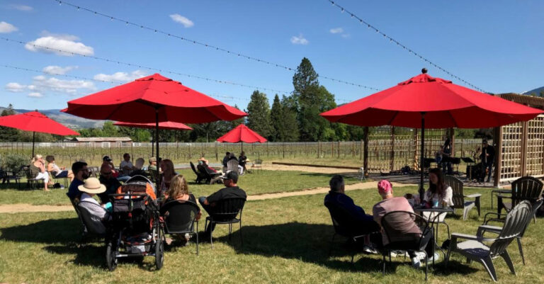 Red umbrellas on the lawn at Pebblestone Cellars Tasting Room